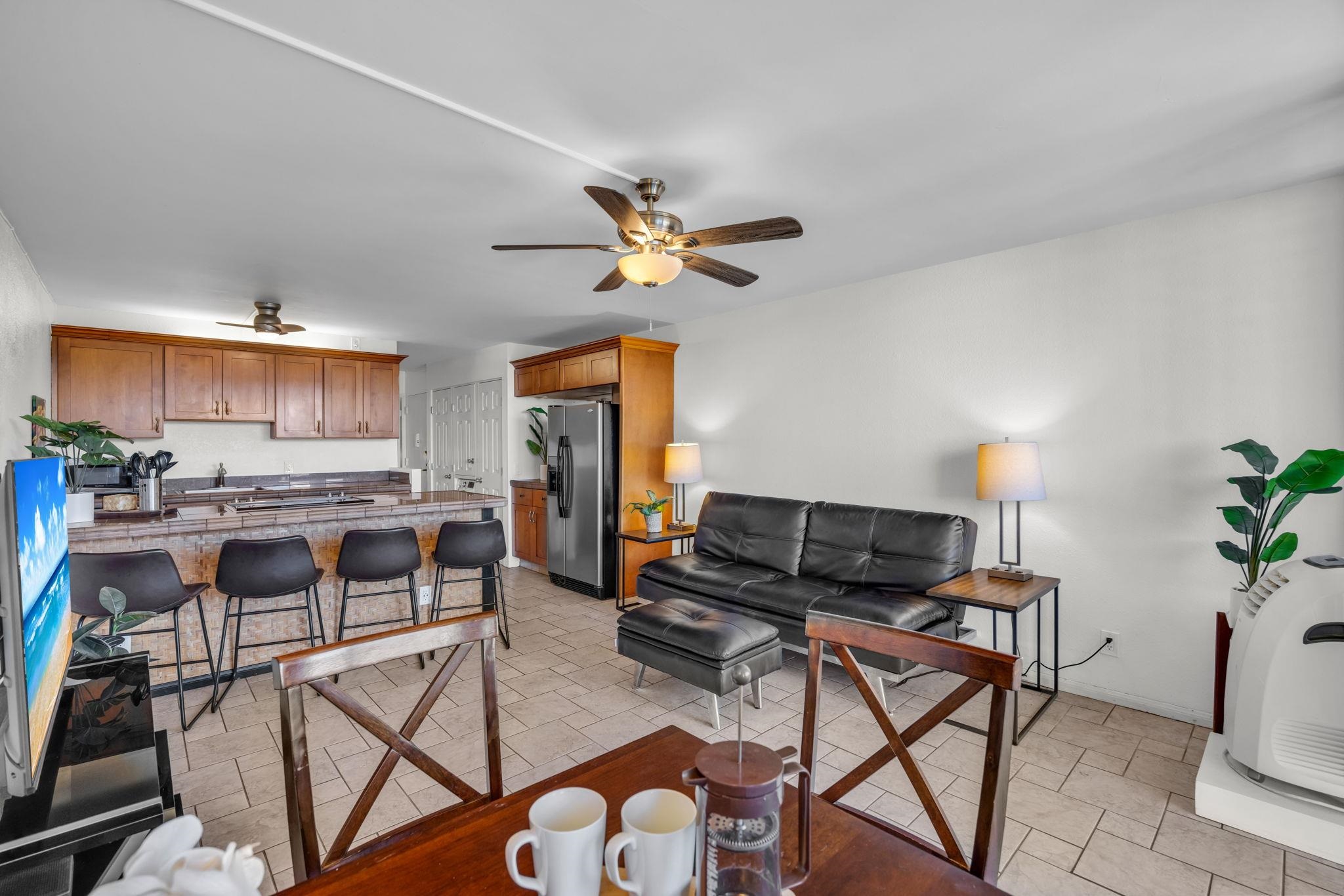 2191 South Kihei Road, Unit 2306 Kihei, HI 96753 - Photo 7 of 41 a living room with furniture a fireplace and a flat screen tv