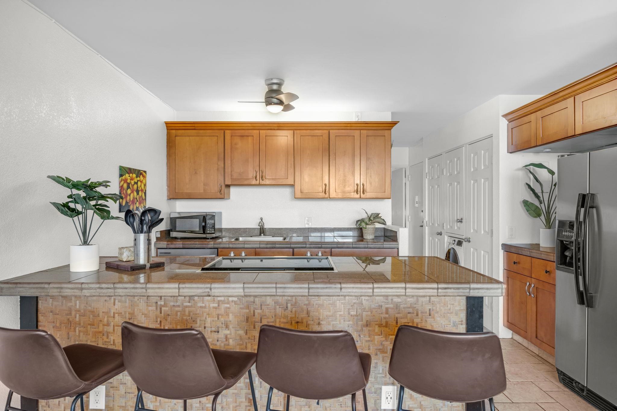 2191 South Kihei Road, Unit 2306 Kihei, HI 96753 - Photo 8 of 41 a kitchen with stainless steel appliances granite countertop a sink a stove and chairs