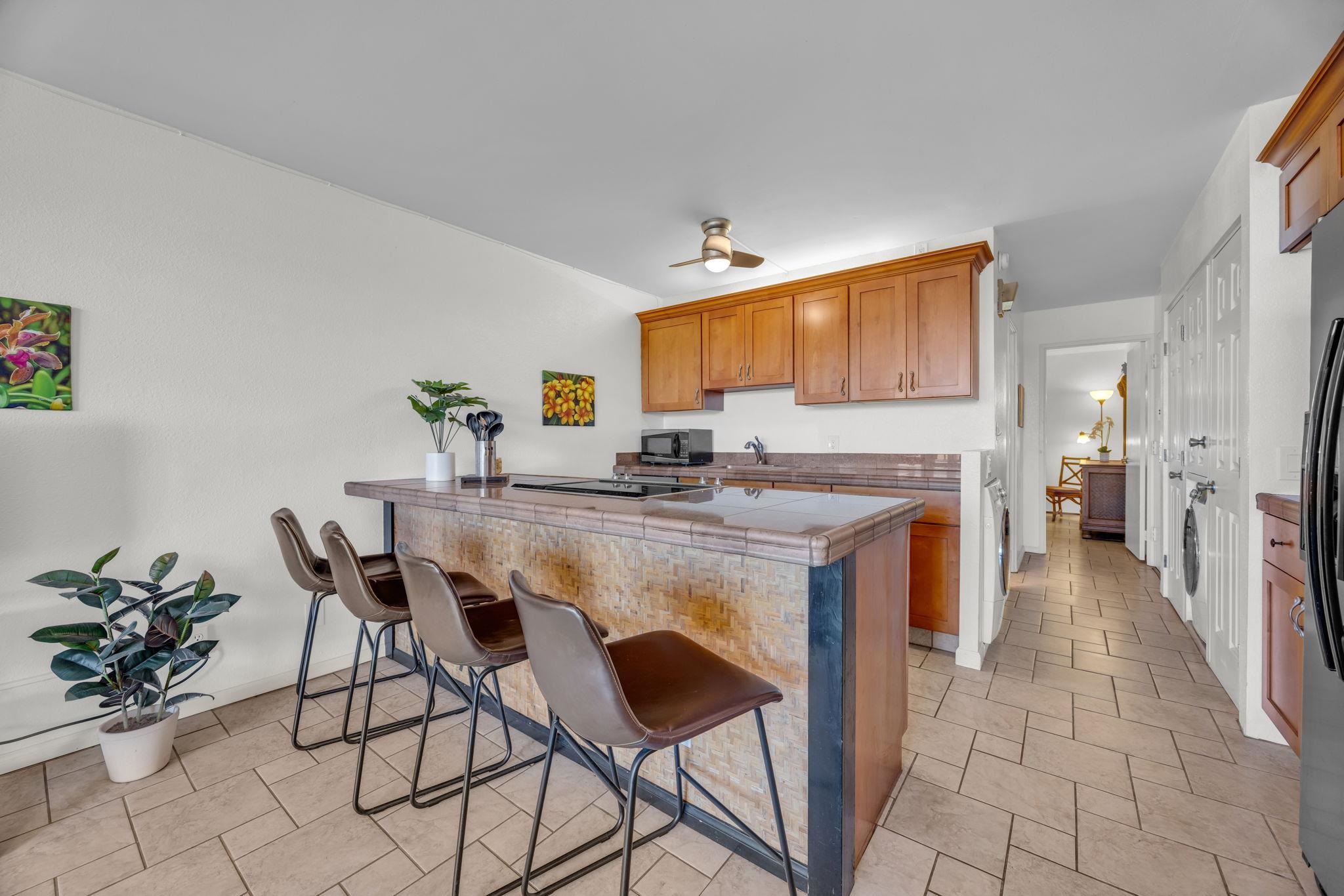 2191 South Kihei Road, Unit 2306 Kihei, HI 96753 - Photo 9 of 41 a kitchen with stainless steel appliances kitchen island granite countertop a sink and a refrigerator