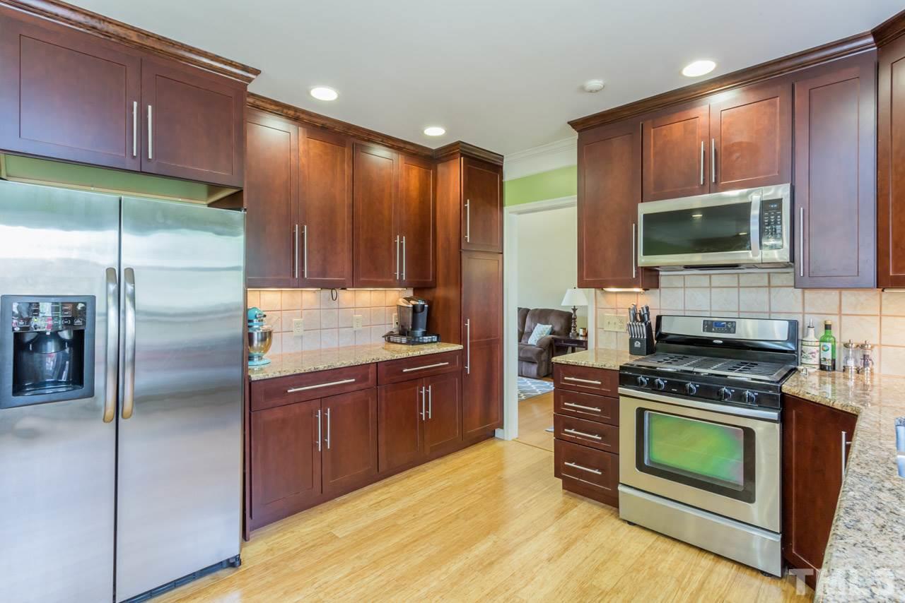4305 Birmingham Way Raleigh, NC 27604 - Photo 2 of 23 a kitchen with stainless steel appliances granite countertop a stove a sink and a microwave