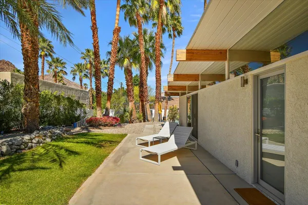 a view of a patio with a table and chairs under an umbrella