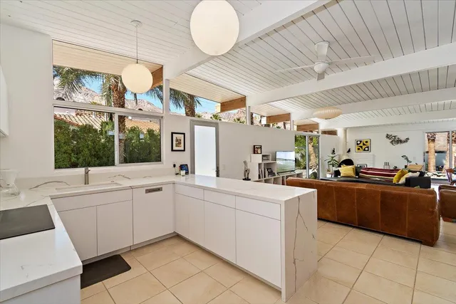 a large white kitchen with a large window