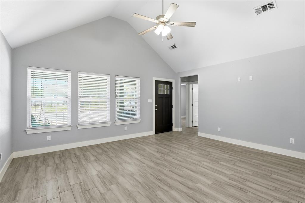 318 Munson Street Denison, TX 75021 - Photo 8 of 21 a view of an empty room with a window and wooden floor