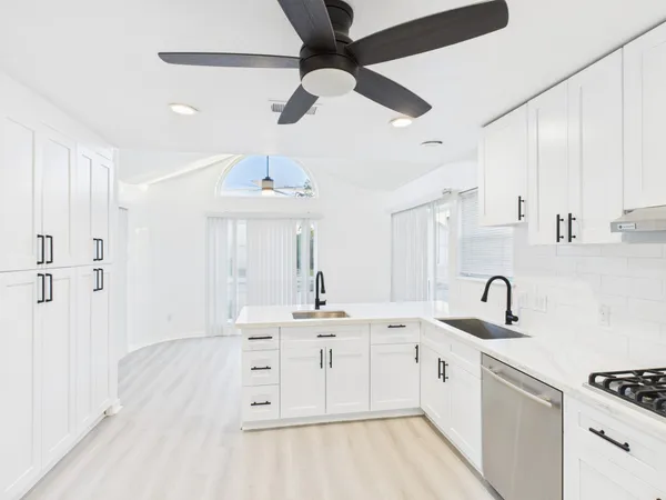 a kitchen with granite countertop a sink stainless steel appliances and cabinets