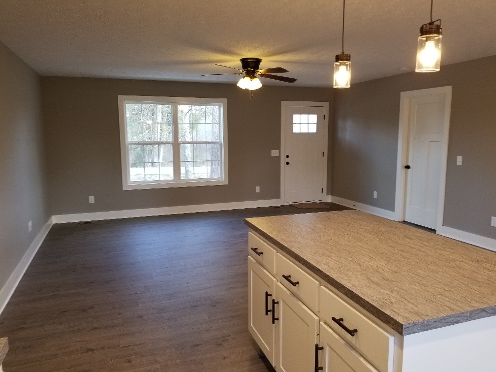 210 Hog Back Ridge Road Bethpage, TN 37022 - Photo 4 of 13 an empty room with wooden floor fan and windows