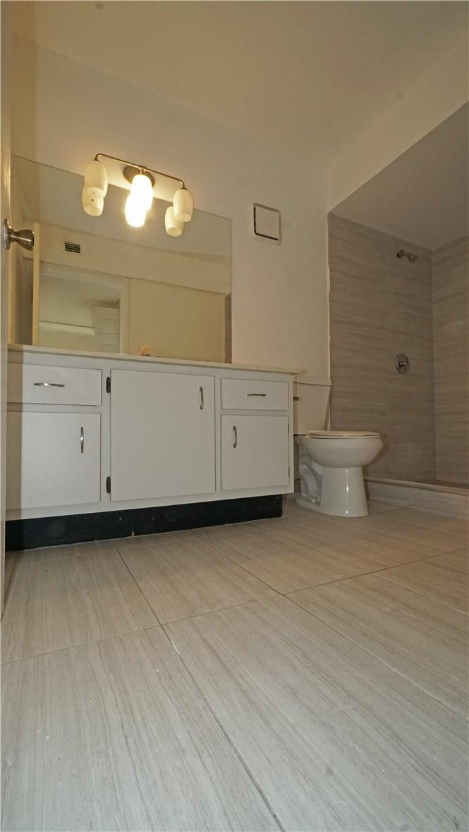 16400 Golf Club Road, Unit 305 Weston, FL 33326 - Photo 16 of 24 a bathroom with a sink a toilet and mirror
