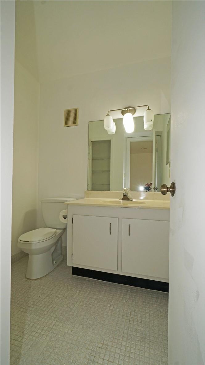 16400 Golf Club Road, Unit 305 Weston, FL 33326 - Photo 19 of 24 a bathroom with a toilet sink and mirror
