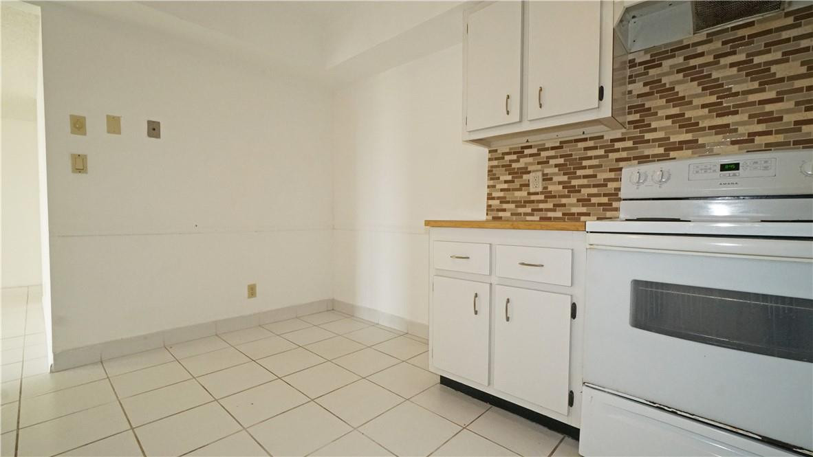 16400 Golf Club Road, Unit 305 Weston, FL 33326 - Photo 22 of 24 a kitchen with white cabinets and white appliances