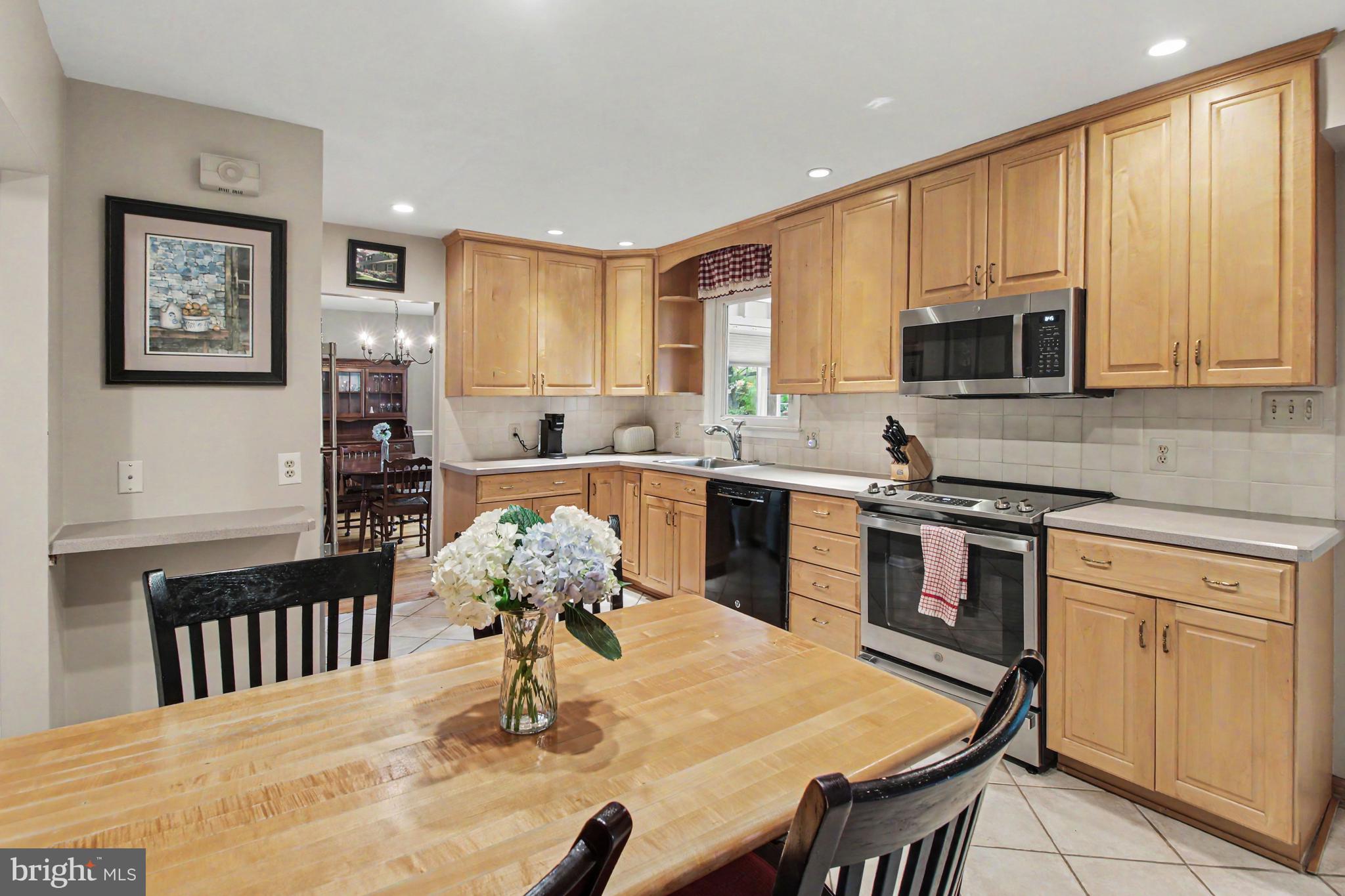917 Cedar Grove Road Broomall, PA 19008 - Photo 11 of 33 a kitchen with stainless steel appliances granite countertop a stove a sink a microwave a dining table and chairs