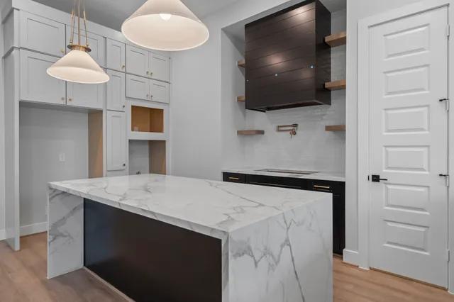 a kitchen with a chandelier and wooden cabinets