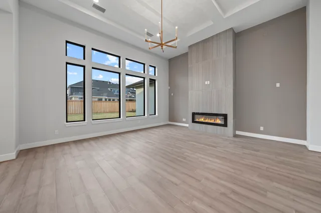a view of a hallway with wooden floor and a kitchen