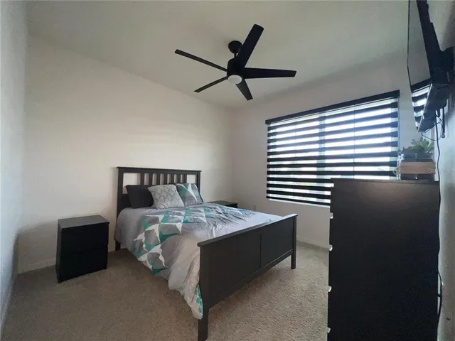 a bedroom with a bed and a ceiling fan