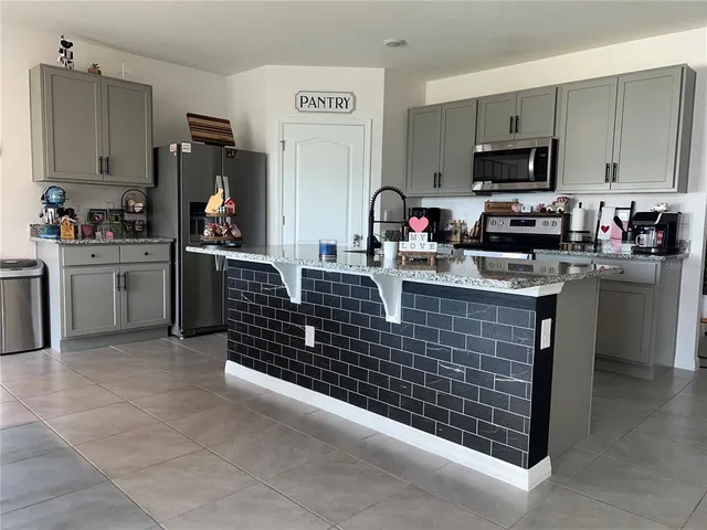 a kitchen with stainless steel appliances granite countertop a sink and a stove