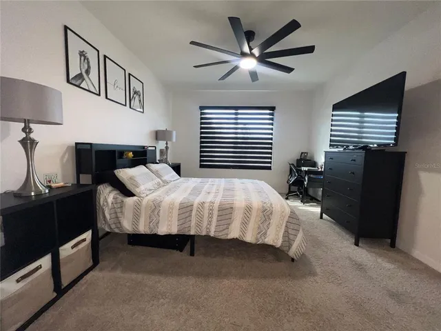 a bed sitting in a bedroom and night stand