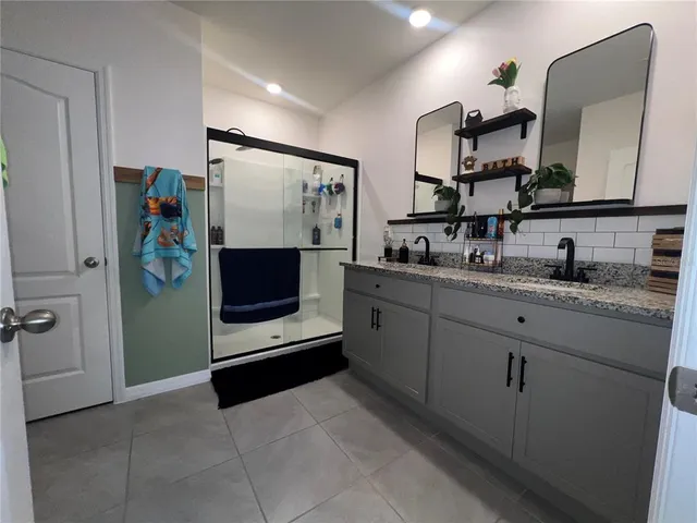 a bathroom with a sink a mirror and a shower