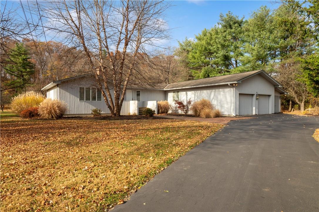 Ranch-style house with a garage and a front lawn