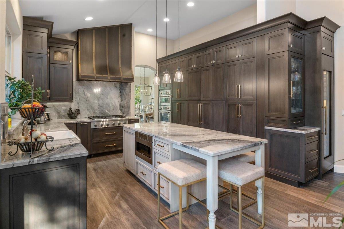 14235 Powder River Court Reno, NV 89511 - Photo 12 of 40 a kitchen with kitchen island granite countertop stainless steel appliances a sink stove and refrigerator