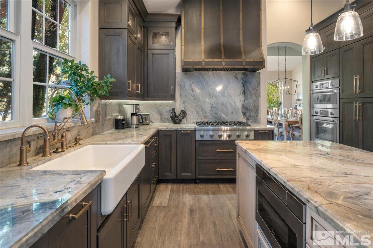 14235 Powder River Court Reno, NV 89511 - Photo 13 of 40 a kitchen with kitchen island granite countertop a sink stove and cabinets