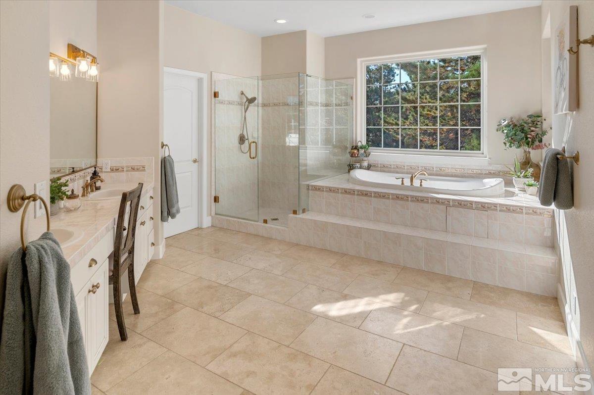 14235 Powder River Court Reno, NV 89511 - Photo 21 of 40 a bathroom with a tub sink and glass door shower