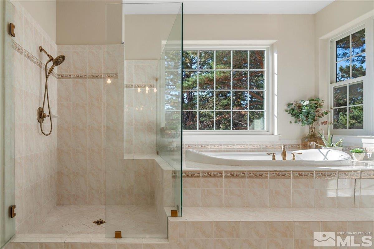 14235 Powder River Court Reno, NV 89511 - Photo 22 of 40 a bathroom with a granite countertop sink a mirror and a glass door shower