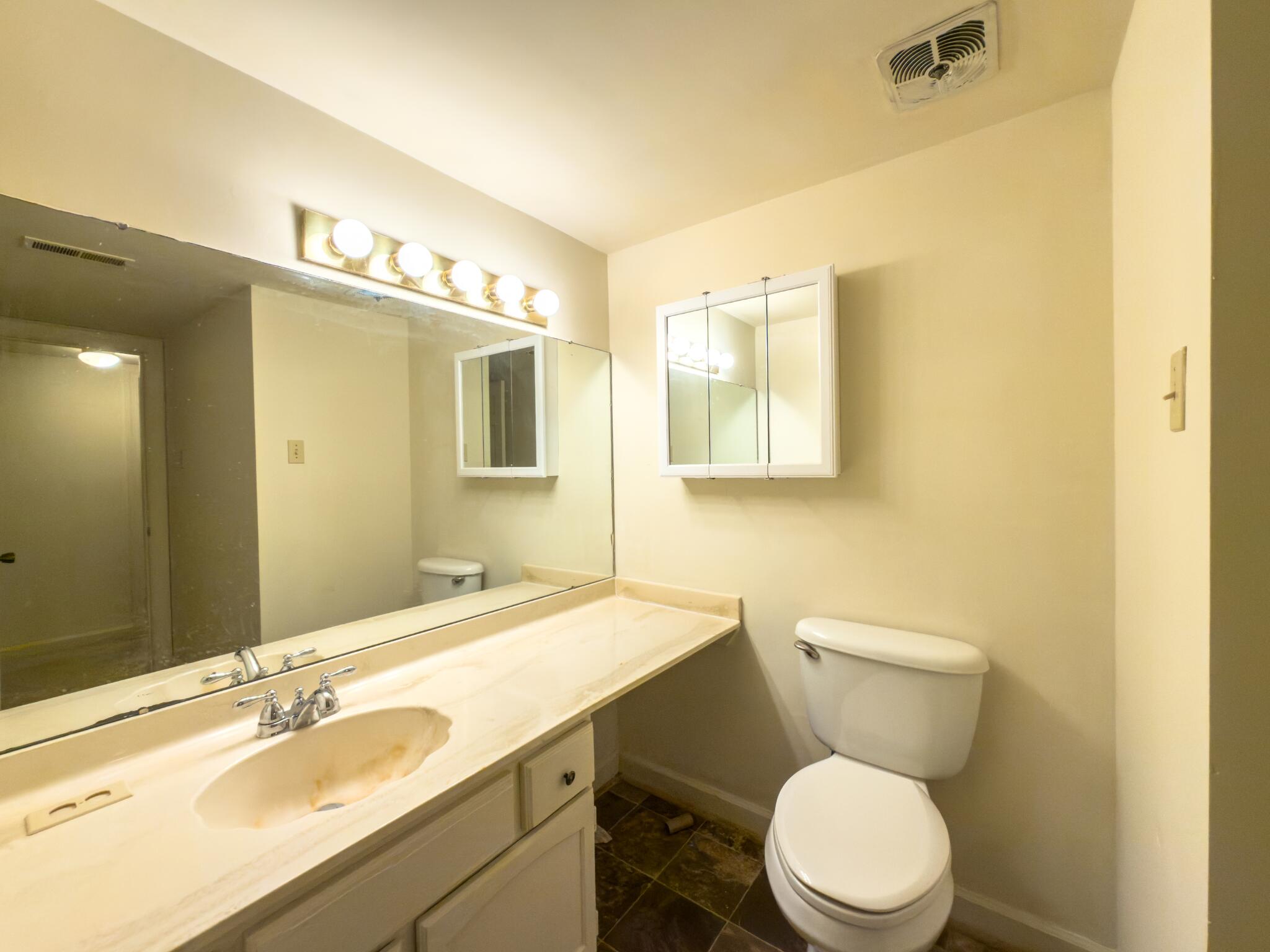 847 King James Street Southwest, Unit A Roanoke, VA 24014 - Photo 9 of 9 a bathroom with a granite countertop toilet sink and mirror
