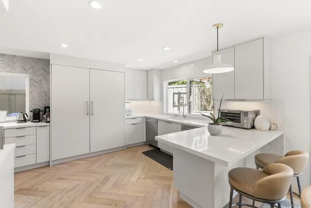 a kitchen with white cabinets and appliances