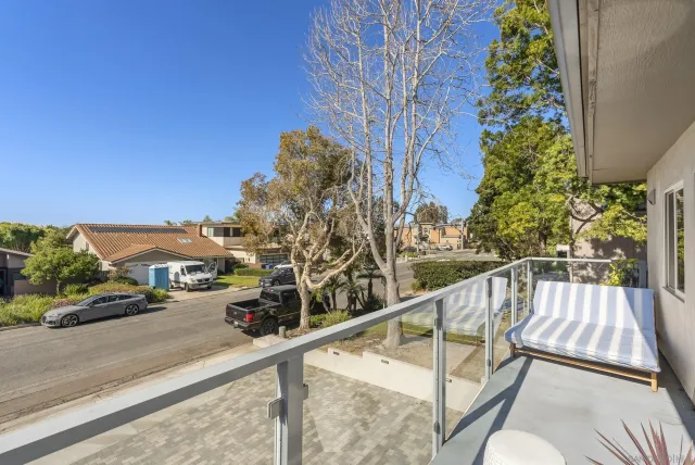 a view of a balcony with wooden floor and outdoor seating