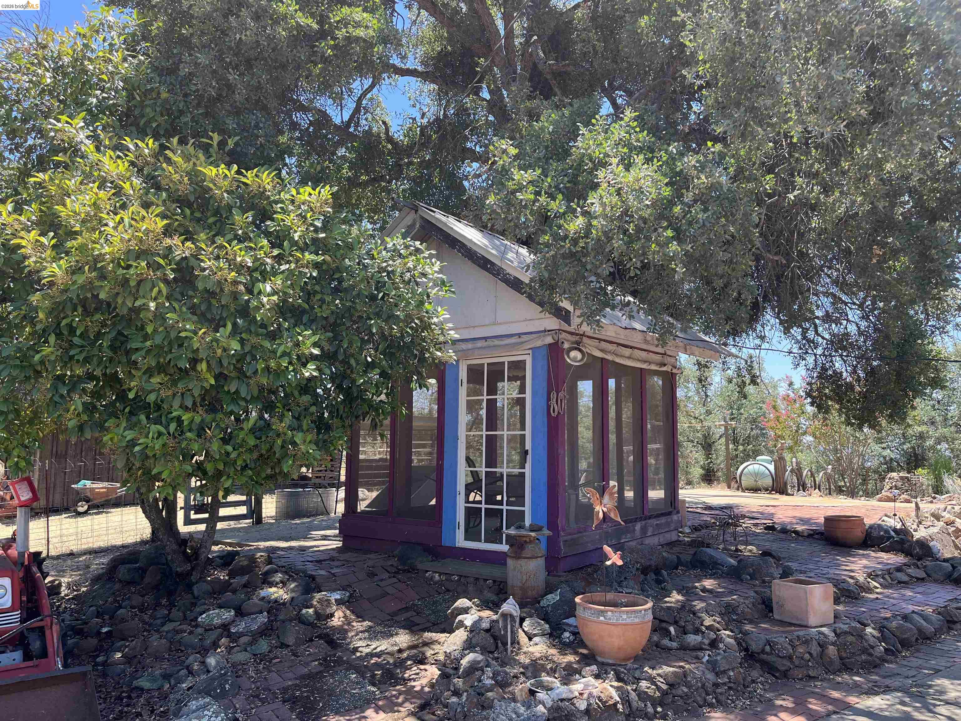 18195 Wards Ferry Road Sonora, CA 95370 - Photo 45 of 67 Freestanding structure with a white-painted gable roof and purple-painted exterior walls, featuring a glass-paneled entry door and multiple large windows