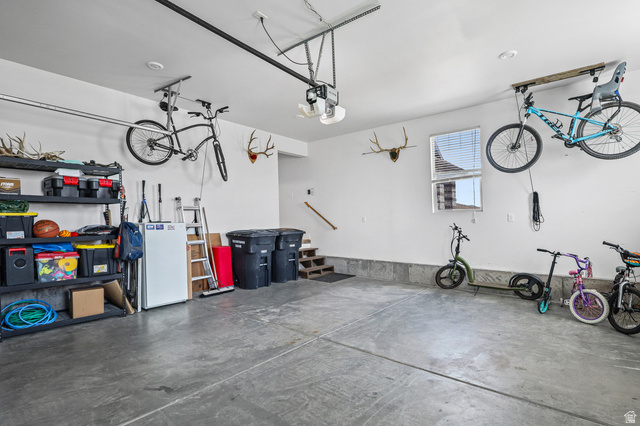 1588 West Rim Rock Drive Stockton, UT 84071 - Photo 36 of 61 Spacious garage featuring a concrete floor, white walls, and a window for natural light