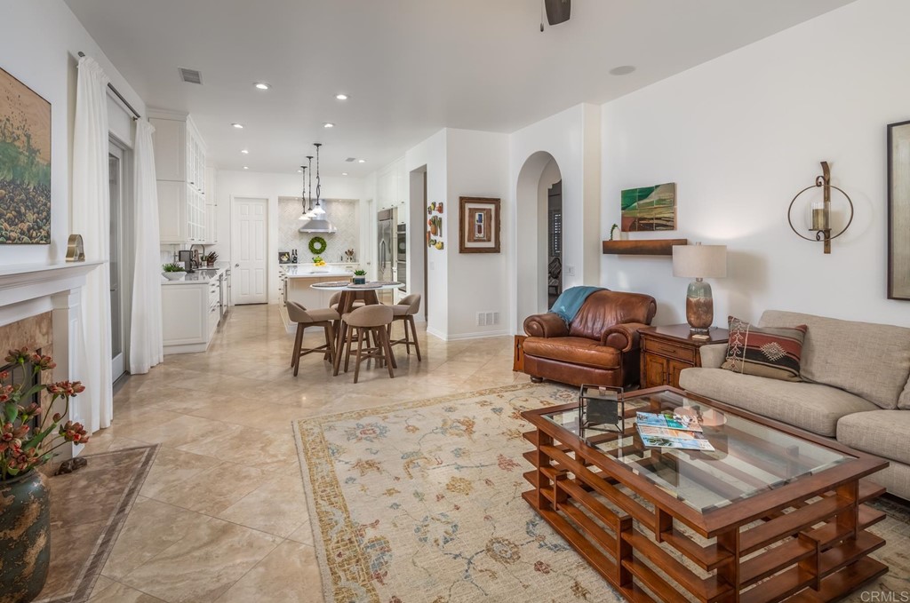 1464 Schoolhouse Way San Marcos, CA 92078 - Photo 19 of 48 a living room with furniture a fireplace and a dining table with wooden floor
