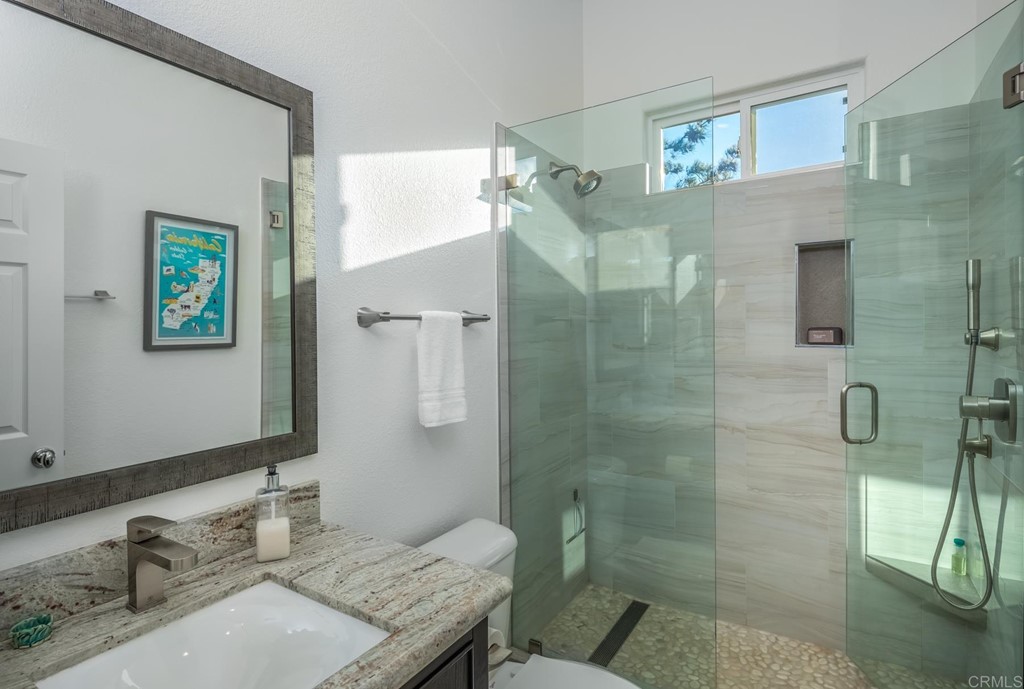 1464 Schoolhouse Way San Marcos, CA 92078 - Photo 28 of 48 a bathroom with a granite countertop sink a mirror and a shower