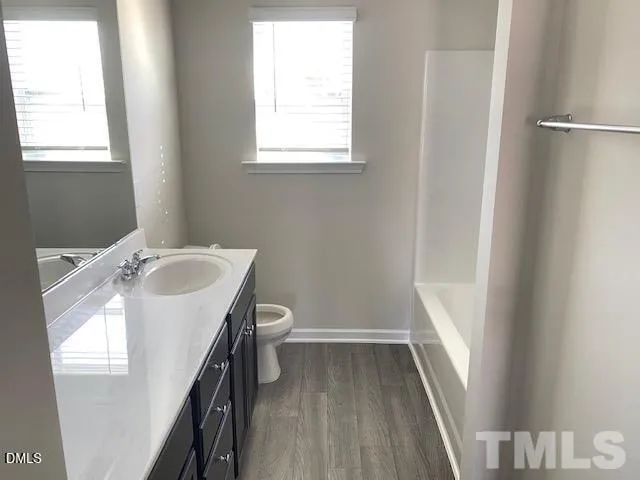 a bathroom with a sink toilet and window