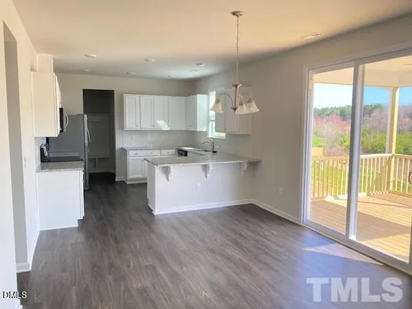 a view of kitchen with wooden floor and electronic appliances