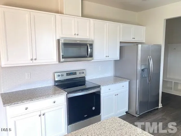 a kitchen with cabinets stainless steel appliances and a counter space