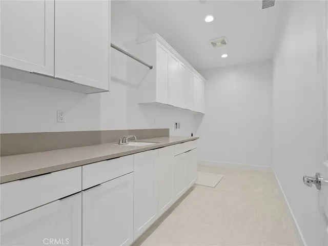 a kitchen with granite countertop a sink and a white cabinets