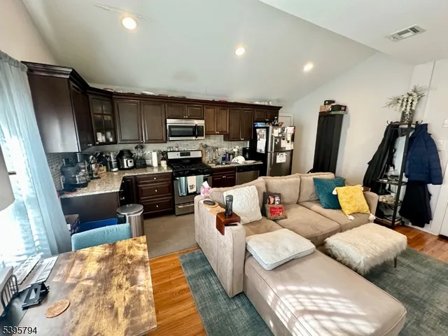 a living room with furniture a flat screen tv and a rug