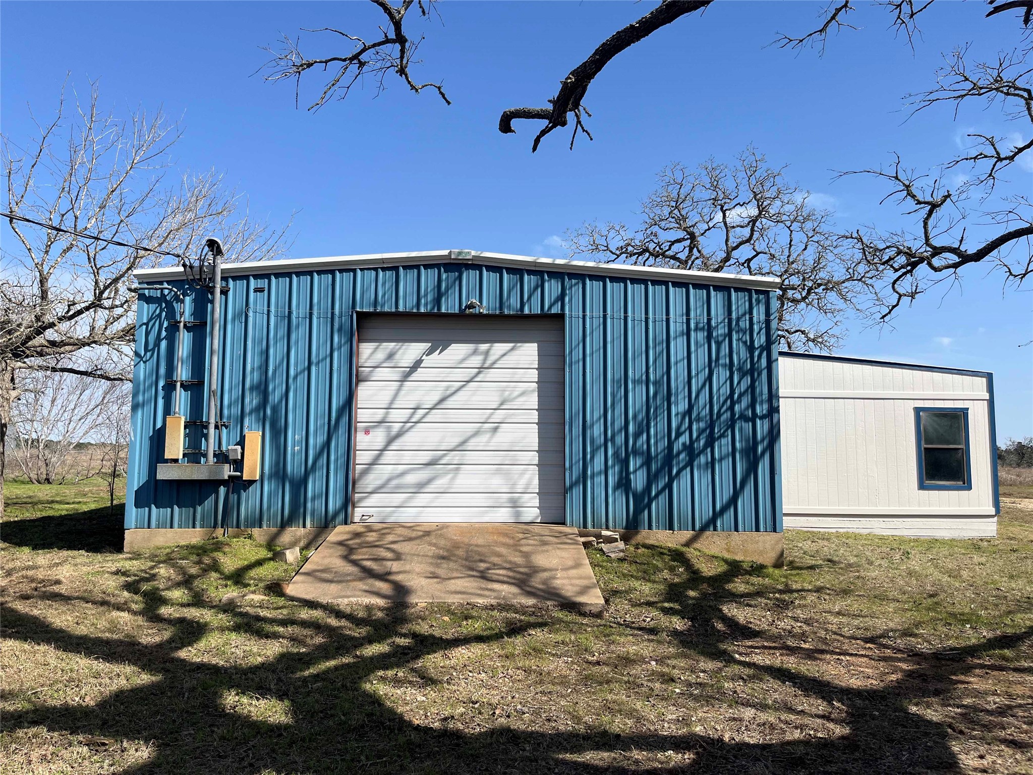 741 Knobbs Road McDade, TX 78650 - Photo 32 of 38 A metal workshop with a large roll-up door provides ample space for projects or storage.
