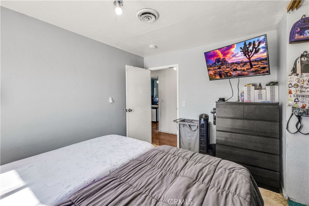4805 Avenida La Mirada Joshua Tree, CA 92252 - Photo 22 of 38 a bedroom with a bed and a flat screen tv