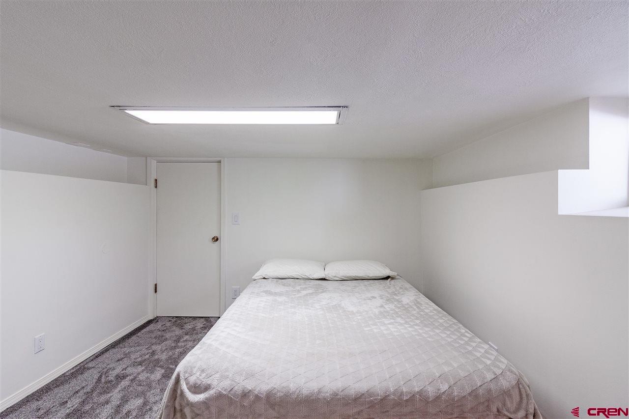 1404 East 3rd Avenue Durango, CO 81301 - Photo 17 of 24 a bed sitting in a room next to a lamp