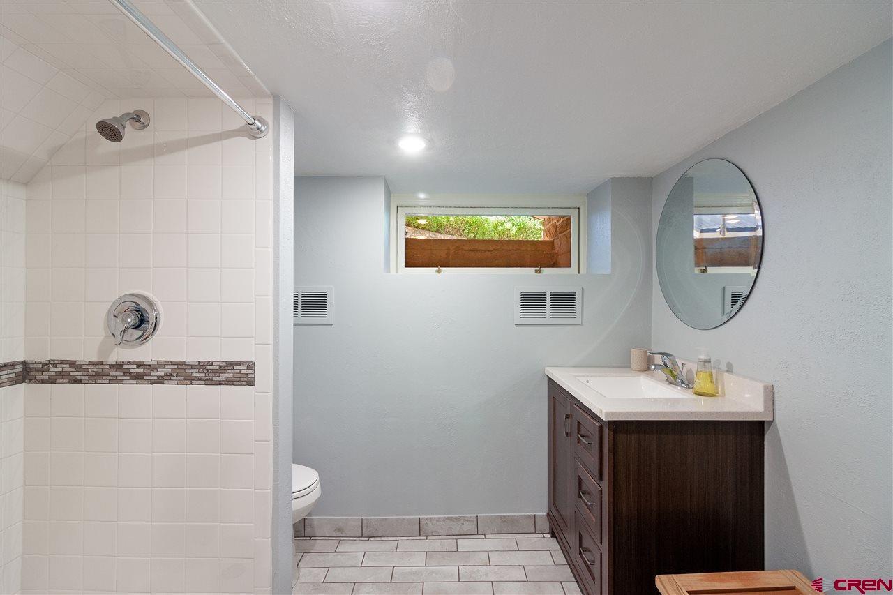 1404 East 3rd Avenue Durango, CO 81301 - Photo 18 of 24 a bathroom with a sink a mirror and a toilet