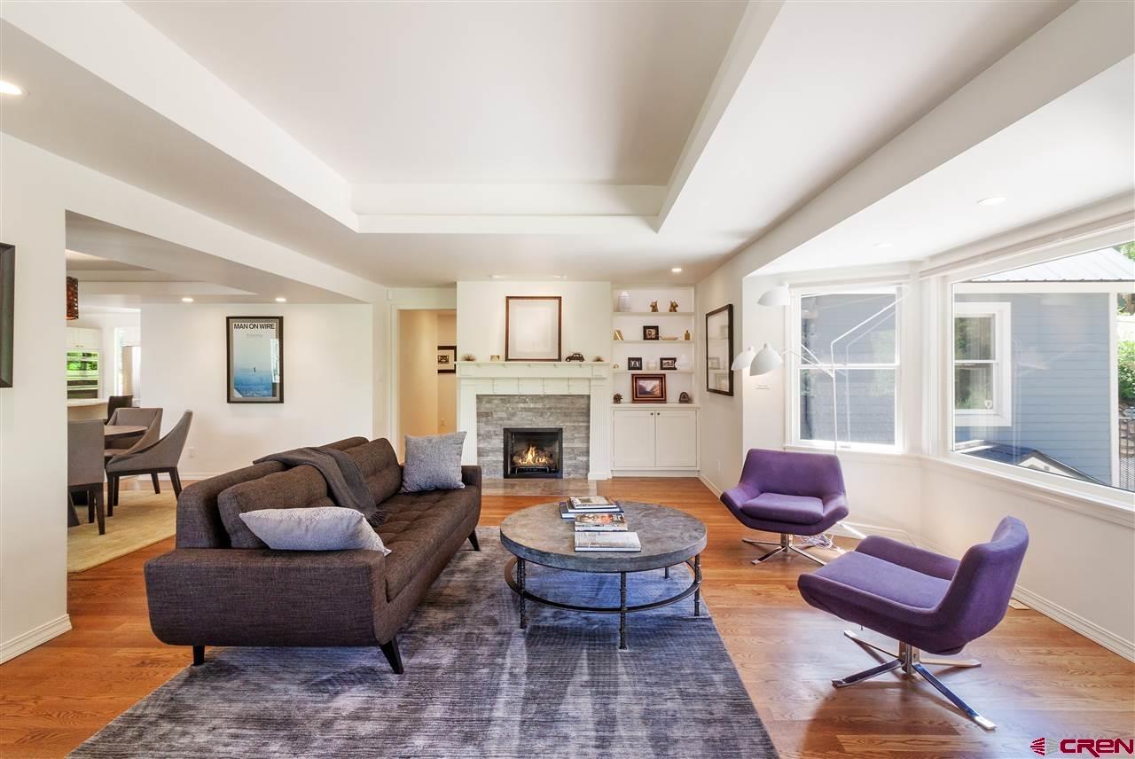 1404 East 3rd Avenue Durango, CO 81301 - Photo 3 of 24 a living room with furniture a fireplace and large windows