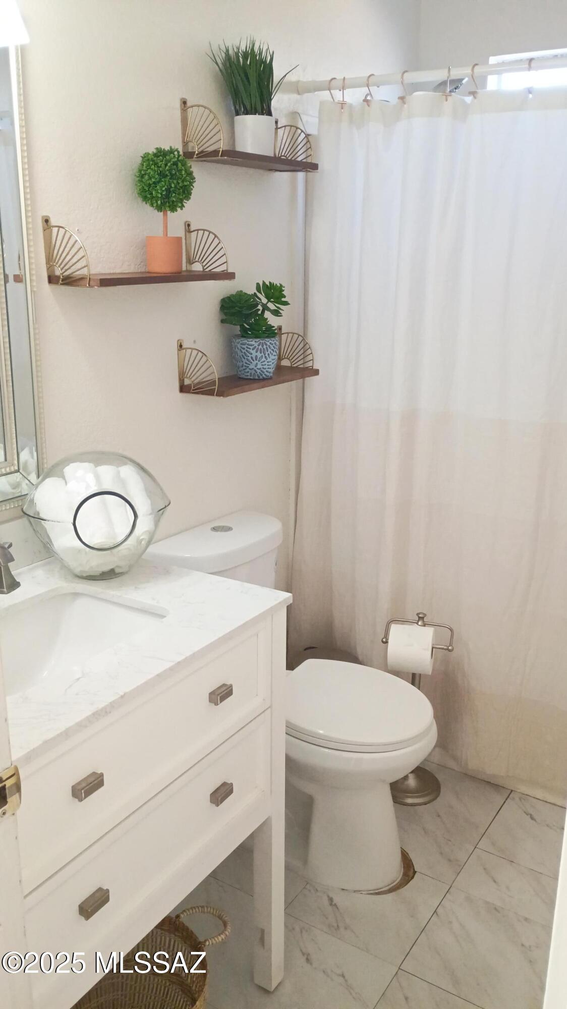 1449 West Hualpai Road Tucson, AZ 85745 - Photo 24 of 49 a bathroom with a sink a toilet and a mirror