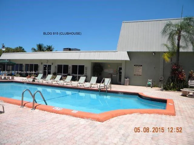 a view of a swimming pool with couches chairs under an umbrella
