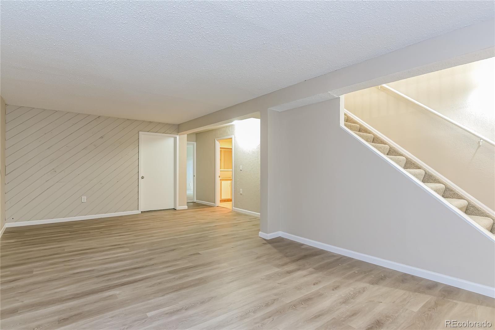 16797 East Mansfield Circle Aurora, CO 80013 - Photo 7 of 17 a view of an empty room with wooden floor