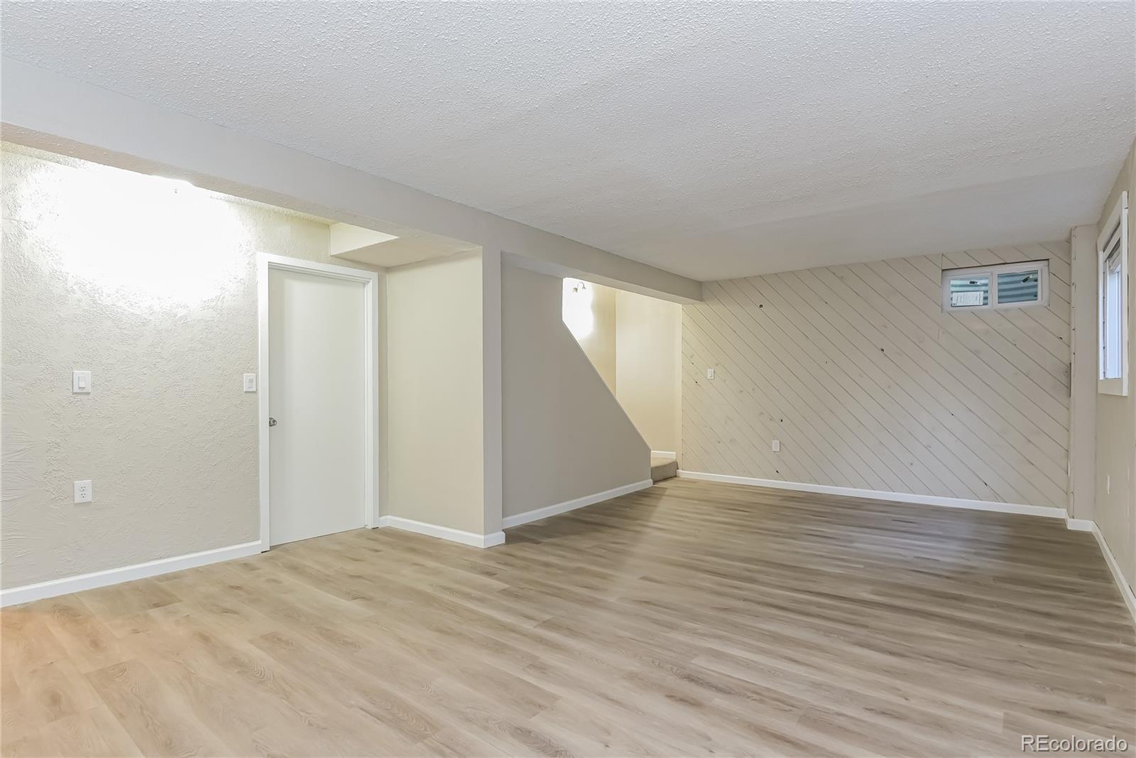 16797 East Mansfield Circle Aurora, CO 80013 - Photo 8 of 17 a view of an empty room with wooden floor