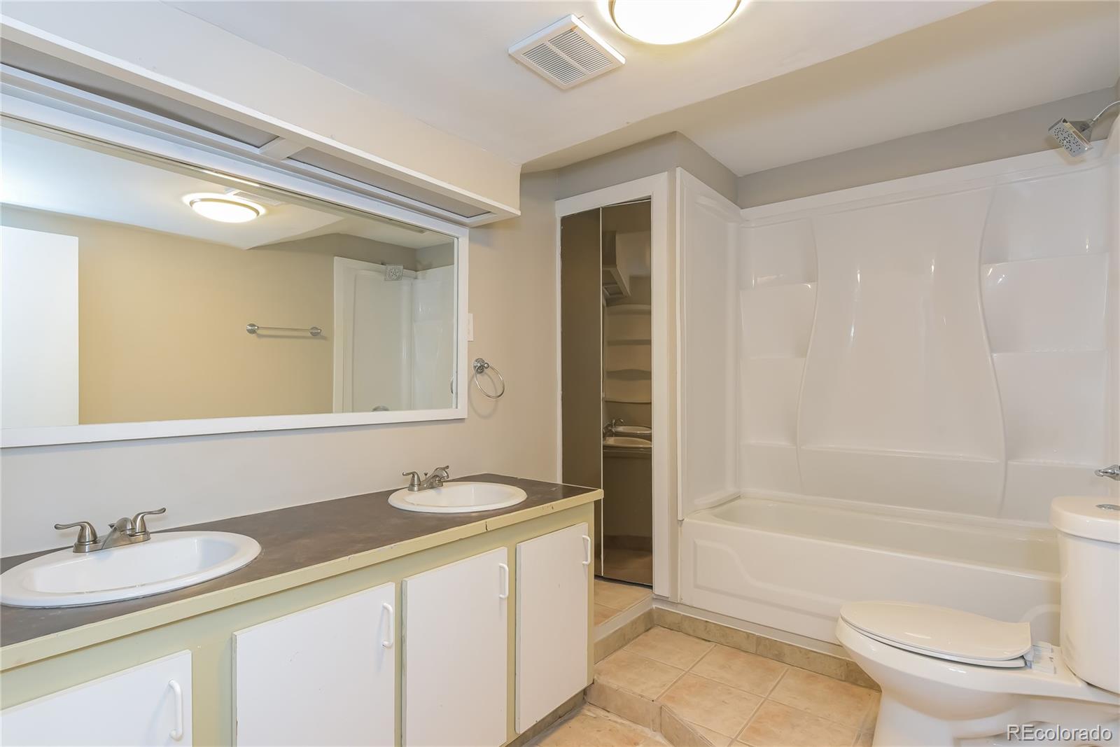 16797 East Mansfield Circle Aurora, CO 80013 - Photo 10 of 17 a bathroom with a granite countertop sink toilet and shower