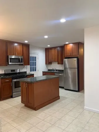 a kitchen with stainless steel appliances granite countertop a refrigerator sink and microwave