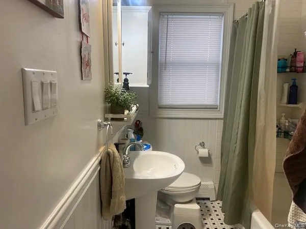 a bathroom with a sink a toilet a mirror and shower