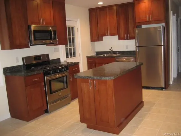 a kitchen with wooden cabinets and stainless steel appliances