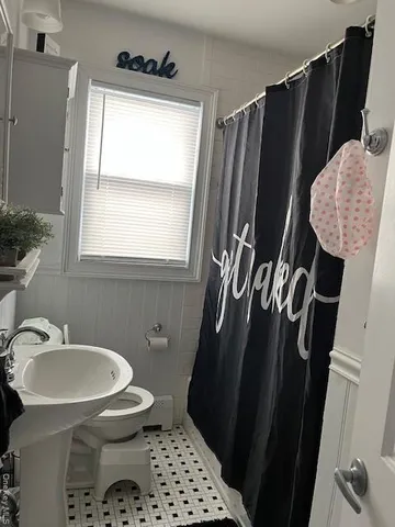 a bathroom with a sink and mirror with toilet